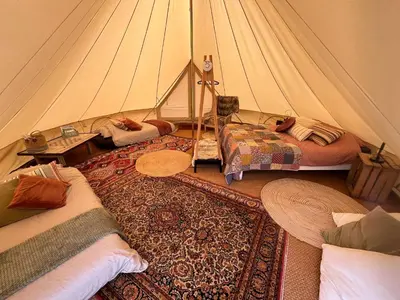 a room with a tent with two beds and a rug at Glamping Josephine in Geel