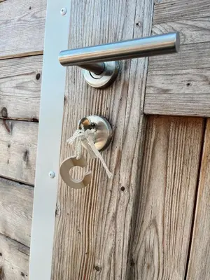 a lock on a wooden door with a key at Glamping Josephine in Geel