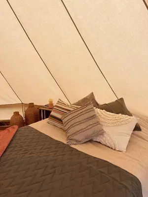 a bed in a tent with pillows on it at Glamping Josephine in Geel