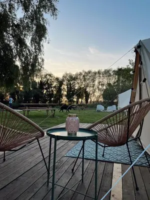 a patio with two chairs and a table on a deck at Glamping Josephine in Geel