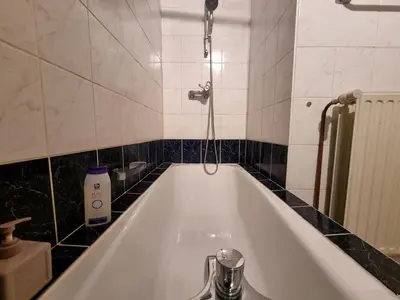 a bath tub in a bathroom with black and white tiles at Chinese Pavilion Park - Magnificent Apartment Brussels in Brussels