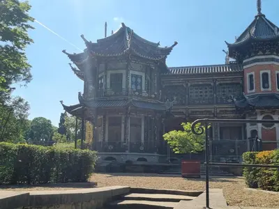 an old building with a clock on the front of it at Chinese Pavilion Park - Magnificent Apartment Brussels in Brussels