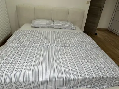 a large bed with a striped mattress in a room at Duplex Apartment in Brussels