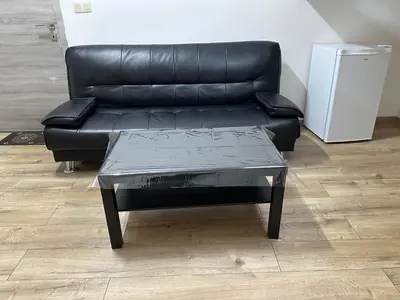 a black leather couch and a coffee table in a room at Duplex Apartment in Brussels