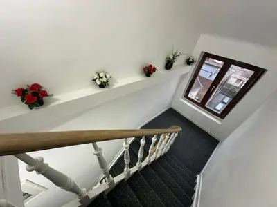 a staircase with flowers on shelves and a window at Duplex Apartment in Brussels