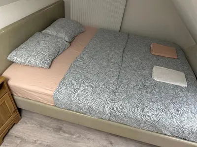a bed in a small room with two pillows at Duplex Apartment in Brussels