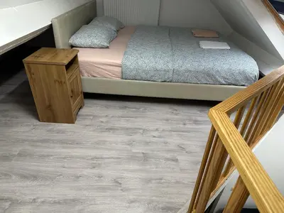 a bedroom with a bed and a wooden table at Duplex Apartment in Brussels