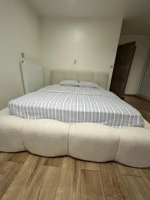 a large bed in a room with a wooden floor at Duplex Apartment in Brussels