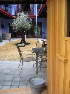 a patio with a table and chairs and a tree at Hotel Van Reeth's Koffiebranderij in Puurs