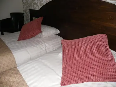 a bed with two red pillows on top of it at Hotel Van Reeth's Koffiebranderij in Puurs