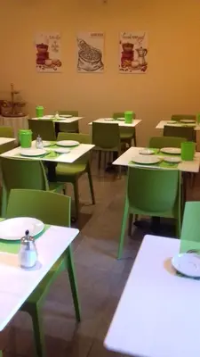 a dining room with tables and green chairs at Hotel Van Reeth's Koffiebranderij in Puurs