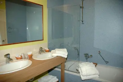 a bathroom with two sinks and a shower at Hotel Van Reeth's Koffiebranderij in Puurs