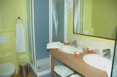 a bathroom with two sinks and a shower at Hotel Van Reeth's Koffiebranderij in Puurs