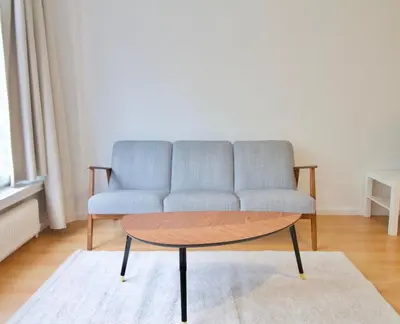a couch and a coffee table in a living room at Very nice & large studio-Plasky in Brussels