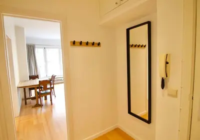 a hallway with a mirror and a table in a room at Very nice & large studio-Plasky in Brussels