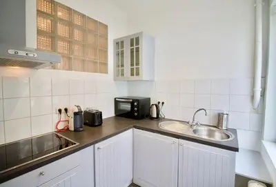 a white kitchen with a sink and a microwave at Very nice & large studio-Plasky in Brussels