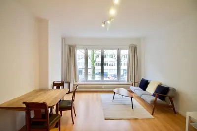 a living room with a table and a couch at Very nice & large studio-Plasky in Brussels