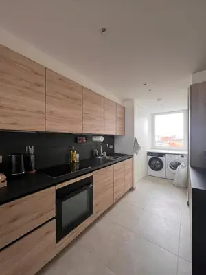 a kitchen with wooden cabinets and black counter tops at Cozy Feels, Central Vibes in Antwerp