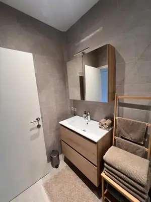 a bathroom with a sink and a mirror and a chair at Cozy Feels, Central Vibes in Antwerp