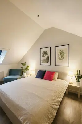 a bedroom with a large bed and two chairs at Habitación con cocina en Gante in Ghent