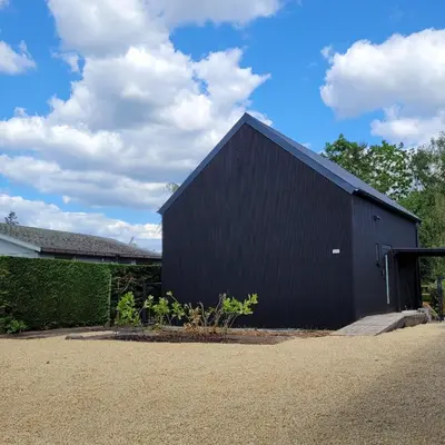 a black building with a black roof at Vakantiewoning aan het water, vissen, wandelen en genieten in de natuur in Geel