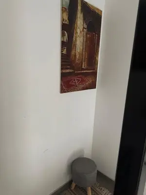 a painting hanging on a wall next to a stool at Appartement boom 2,1 km van tomorrowland in Boom
