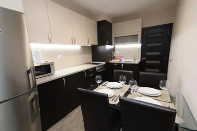 a kitchen with a table with chairs and a refrigerator at Parkzicht Gent in Ghent