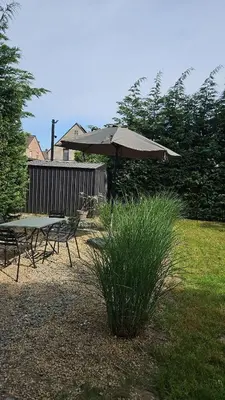 a picnic table and an umbrella in a yard at Huisje in Begijnendijk