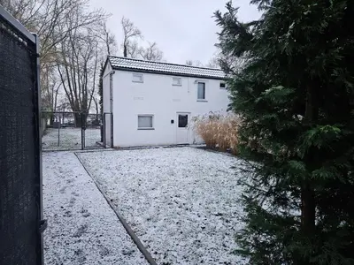 a white house with snow on the ground at Huisje in Begijnendijk