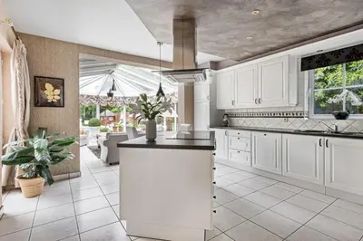 a kitchen with white cabinets and a kitchen island at thomas van der vekenlaan in Brecht
