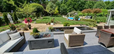 a patio with wicker furniture and a garden with a pool at thomas van der vekenlaan in Brecht
