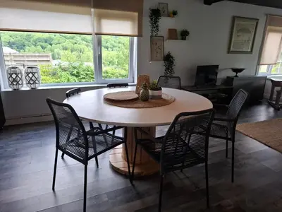 a dining room table and chairs in a living room at Le Loft d'Oli in Overijse