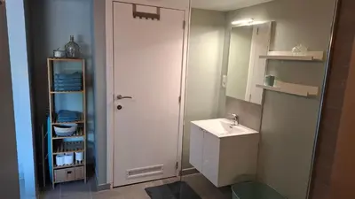 a white bathroom with a sink and a mirror at Le Loft d'Oli in Overijse