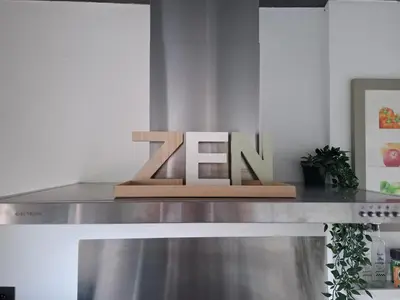 a wooden sign on top of a stainless steel counter at Le Loft d'Oli in Overijse
