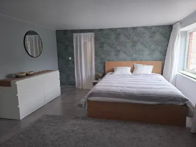 a bedroom with a large bed and a mirror at Le Loft d'Oli in Overijse