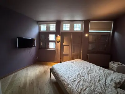 a bedroom with a bed and a tv on the wall at Gent-cosy-stay in Ghent