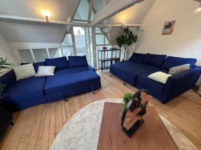 a living room with blue couches and a table at Gent-cosy-stay in Ghent
