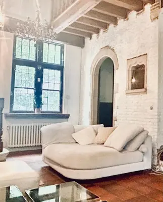 a living room with a white couch and a chandelier at Luxury Hotel-Villa Schaffen in Diest