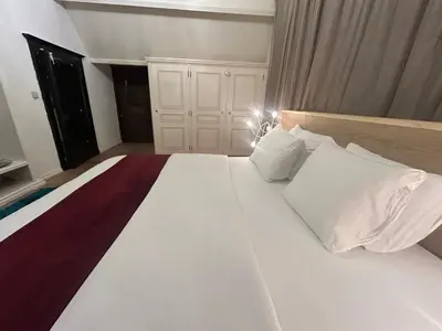 a bedroom with a large bed with white sheets and pillows at Luxury Hotel-Villa Schaffen in Diest