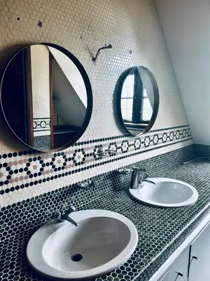 a bathroom with two mirrors above a sink at Luxury Hotel-Villa Schaffen in Diest
