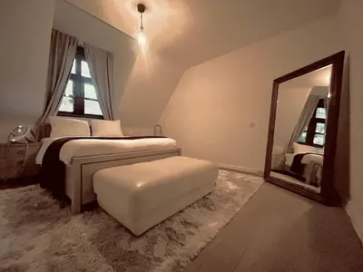 a bedroom with a bed and a mirror and a stool at Luxury Hotel-Villa Schaffen in Diest
