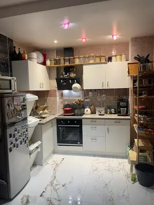 a kitchen with white cabinets and a refrigerator at Petit coin de cosyness in Brussels