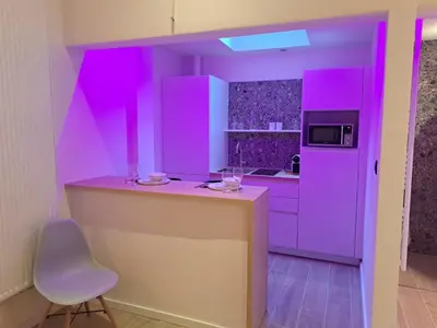 a purple kitchen with a counter and a chair at Boomgaard de Luxe in Antwerp