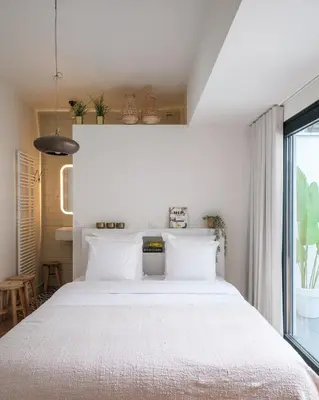 a bedroom with a large white bed and a window at Anno in Ghent