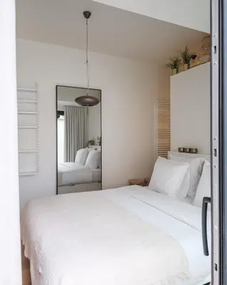 a bedroom with a white bed and a mirror at Anno in Ghent