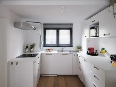 a white kitchen with white cabinets and a sink at Anno in Ghent