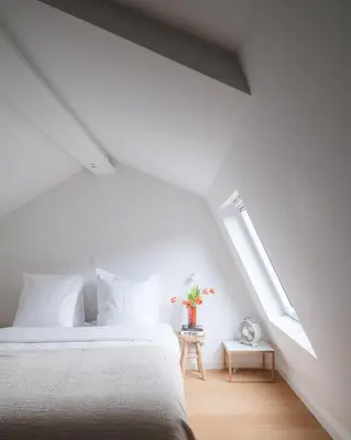 a white bedroom with a bed and a window at Anno in Ghent