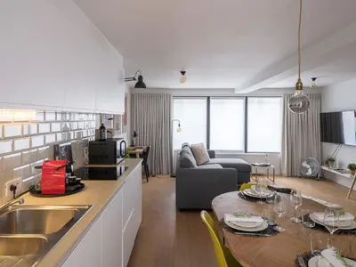 a kitchen and living room with a table and a couch at Anno in Ghent