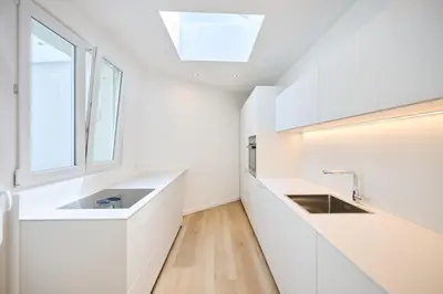 a white kitchen with two sinks and a window at Toison d'Or & Sauna in Brussels