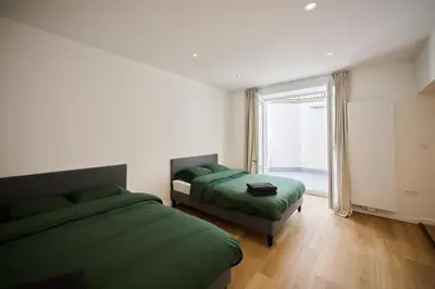 a bedroom with two beds and a large window at Toison d'Or & Sauna in Brussels